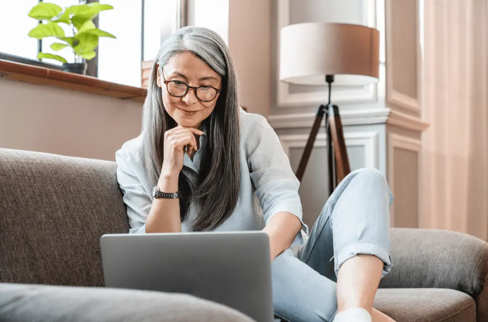 an older woman looking at a computer at home