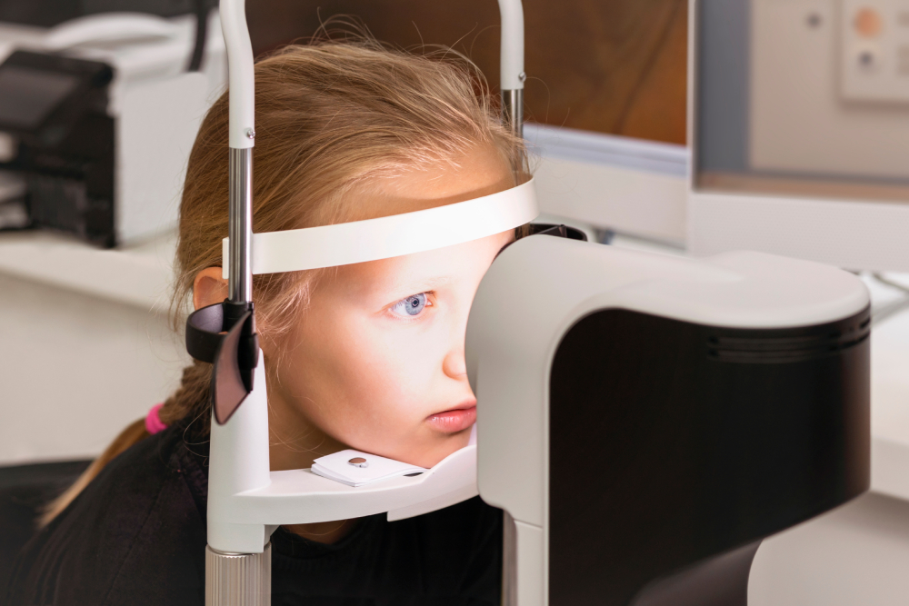 Understanding Myopia Progression in Children A young girl undergoes an eye examination, looking into a medical device at an optometrist's office.