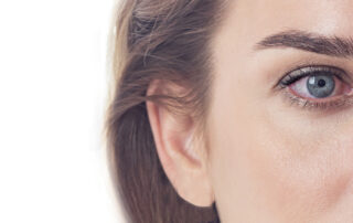 Close-up of the right side of a person’s face, showing blue eye, eyebrow, ear, and part of the cheek with clear skin—highlighting features often examined in cases of dry eye disease.